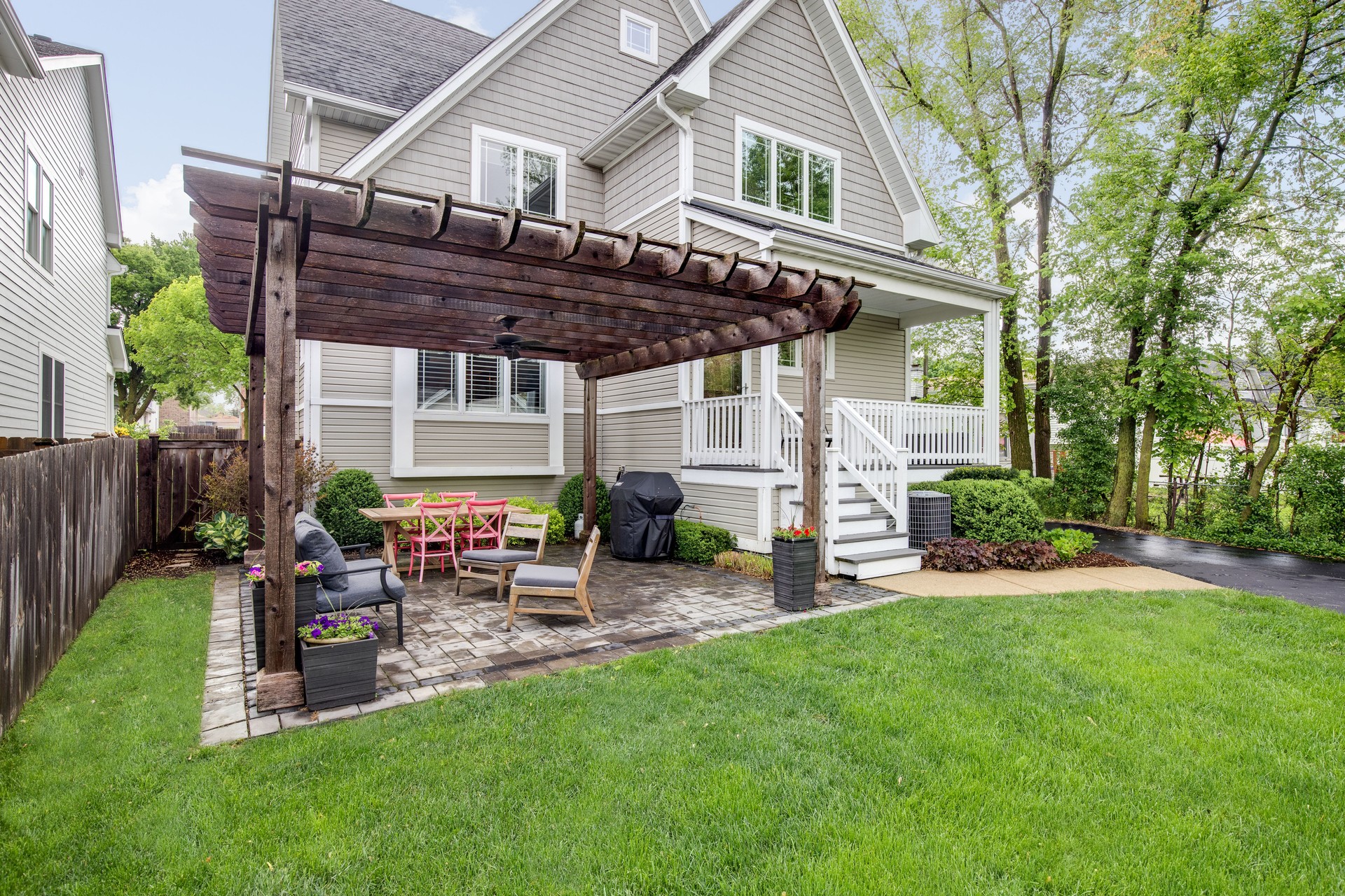 Backyard patio with a pergola over furniture.